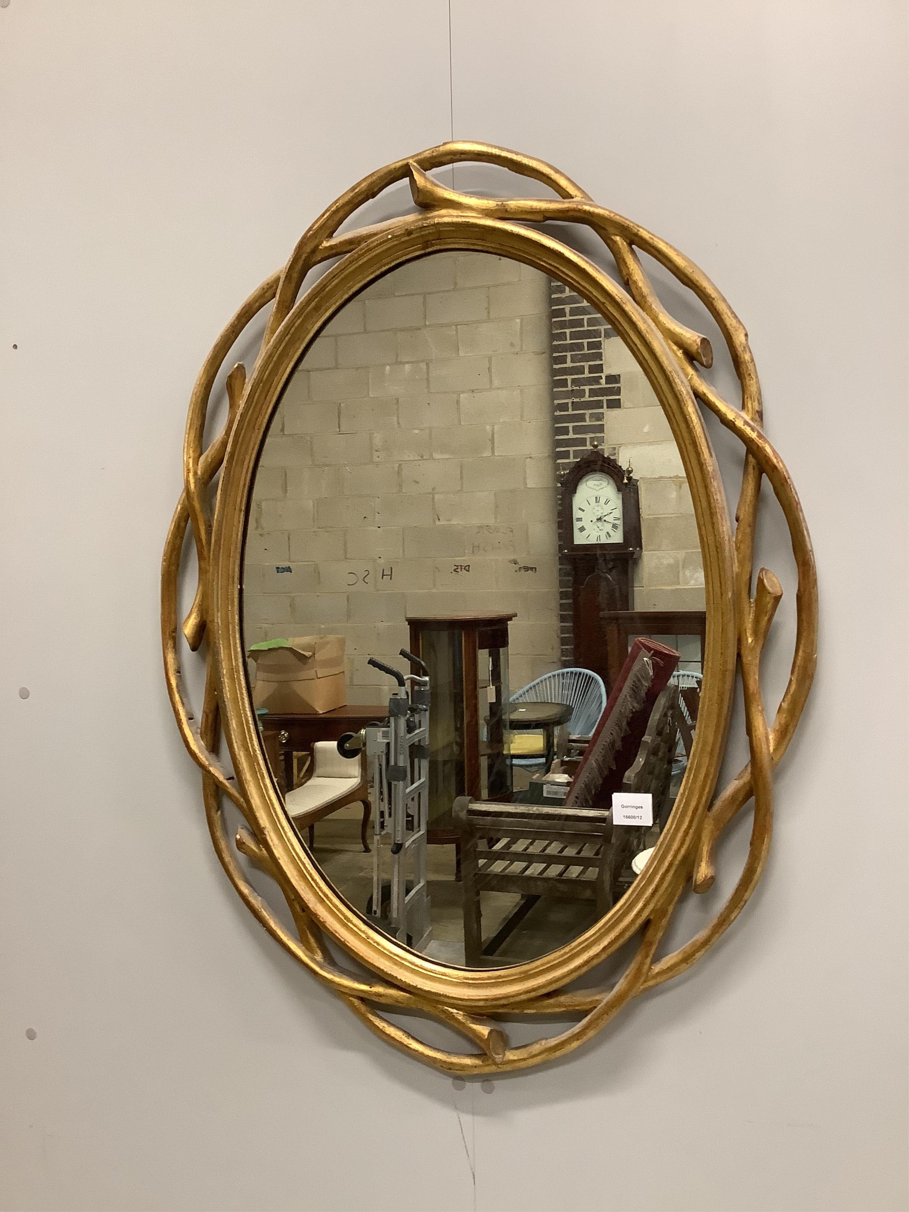 A Contemporary gilt composition oval wall mirror, with branch effect border, width 74cm, height 100cm. Condition - good